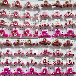 Detailed view of plush Lotso bear claw clips in pink and beige on a display board
