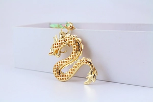 Détail d'un pendentif dragon doré pour porte-clés avec design en maille ajourée