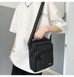Detail of black waterproof nylon crossbody bag with multiple zippers and adjustable strap