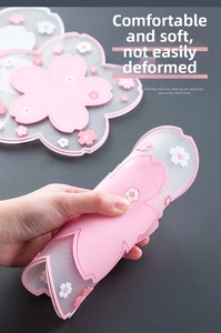 Detail showing the flexibility of a pink cherry blossom silicone coaster with a soft texture