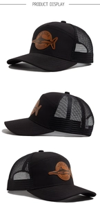 Detail of black trucker hat with brown leather shark patch and breathable mesh back