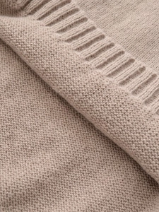 Close-up of high-density knit fabric in beige with detailed ribbed edge texture