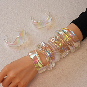 Detailed view of iridescent acrylic resin bangles with varied textures and rainbow sheen