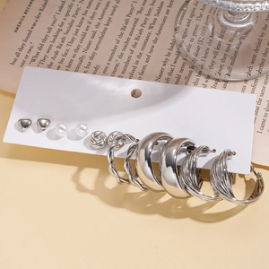Detail of 12-piece silver earring set with hearts, pearls, and hoops on display card