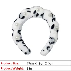 Detail shot of plush black and white cow print headband with pearl accents and dimensions