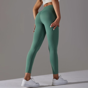 Gros plan d'un legging de yoga vert sauge à taille haute soulignant le galbe des fesses