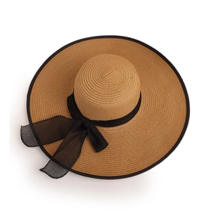 Detail of wide-brim straw hat with fine weave texture and black bow ribbon