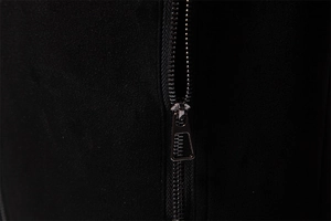 Detail of a high-quality black metal zipper on soft suede fabric with textured puller