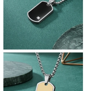 Close-up of military dog tag pendants with diamond inlay in black and gold plating