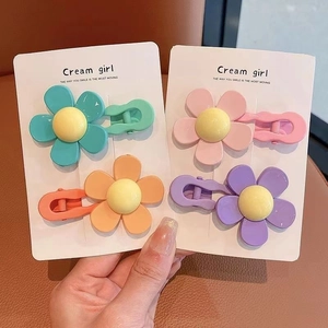 Set of four colorful floral hair clips in blue, orange, pink, and purple for kids