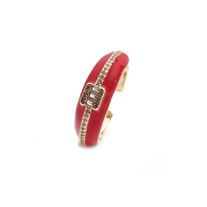 Adjustable gold ring with red enamel and vertical zircon stones on white background