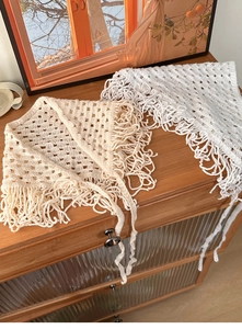 Close-up of crochet hollow triangular headscarf with fringes in beige and white