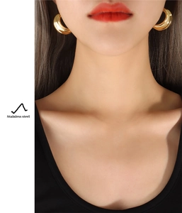 Close-up of chunky C-shape hoop earrings in 18k gold plated polished stainless steel