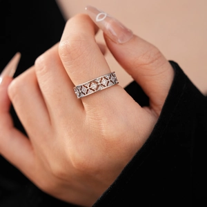 Macro shot of silver plated flower ring with sparkling zircon and hollow geometric details