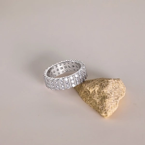 Macro shot of silver ring with three rows of sparkling zircons on a yellow stone