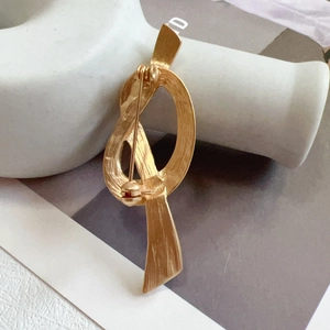 Detailed back view of vintage knot brooch showing secure pin and clasp mechanism