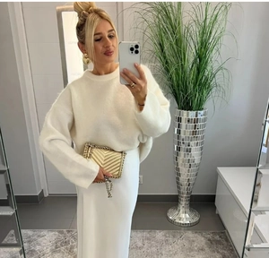 Détail d'un pull en maille blanc oversize avec jupe en satin et sac à chaîne matelassé