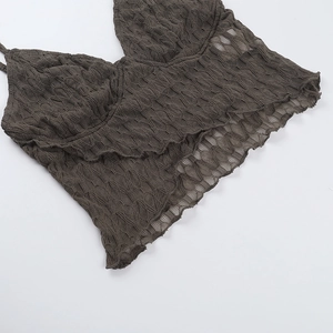 Detailed close-up of dark brown lace knit fabric texture and V-neck strap design
