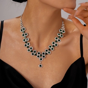 Luxurious emerald and crystal sunflower V-shaped layered necklace on elegant model
