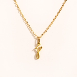 Detailed view of golden pendant necklace featuring letter J and tiny heart motif