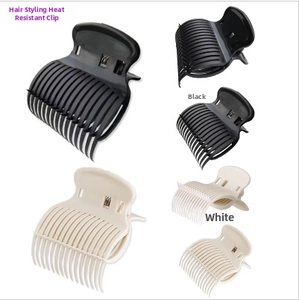 Détail de pinces à cheveux professionnelles noires et blanches pour le coiffage au salon
