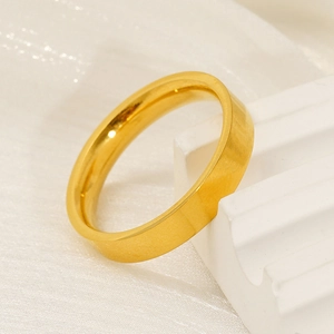 Dettaglio dell'anello minimalista in titanio dorato con finitura spazzolata su base bianca