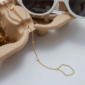 Detailed view of 18K gold plated layered bracelet with zircon and star charms on craft paper