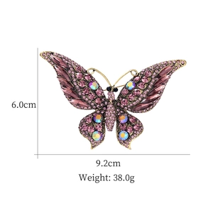 Élégante broche papillon avec strass violets et cristaux irisés sur base en bronze