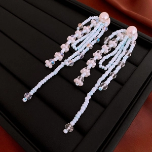 Detailed macro view of elegant blue and white beaded fringe earrings with pearls