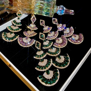 Macro detail of Fan-shaped drop pendant necklace with multi-layer green and purple crystals