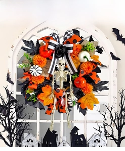 Detail of Halloween wreath with skull, maple leaves, pumpkins and black roses on white window