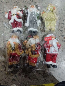 Detailed view of six assorted Santa Claus figurines in red, gray, and gold holiday outfits