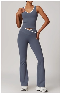 Detail of dusty blue yoga set with contrast piping and cross-waist flare leggings