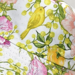 Gros plan du tissu à motif floral et oiseau avec coutures sur le chapeau bob