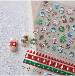 Macro detail of Christmas nail art stickers featuring Santa, snowman and festive patterns