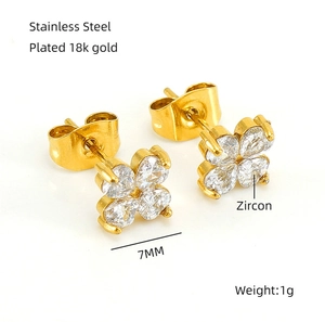 Détail macro de boucles d'oreilles trèfle 7mm plaquées or 18k avec zircons et mesures