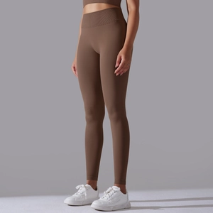 Detail of high-waist dark brown seamless yoga leggings and crop top set with knit texture