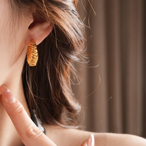 Close-up of 18k gold plated hollow hoop earring shown on a model's ear for high-end look