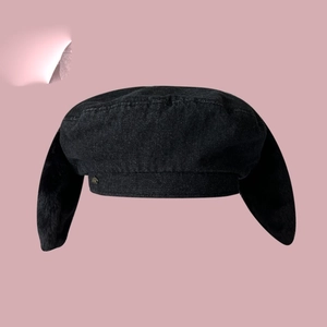 Détail du béret en denim noir avec de longues oreilles de lapin en peluche sur rose