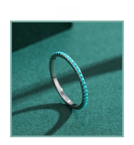Detail of S925 sterling silver ring featuring pave turquoise stones on a green velvet base