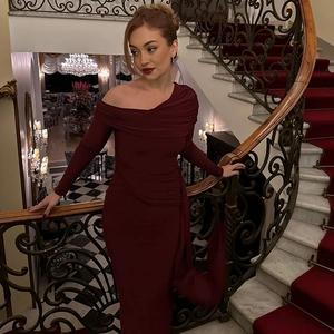 Elegant wine red off-shoulder gown with pleated waist detail on luxury marble stairs