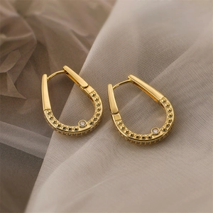 Macro shot of 18K gold plated horseshoe earrings with bead details and sparkling zircon
