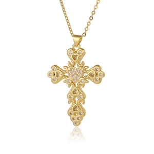 Detailed close-up of a golden cross pendant necklace with sparkling cubic zirconia inlay