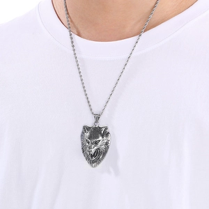 Detailed view of punk wolf head pendant with silver textured chain on neck