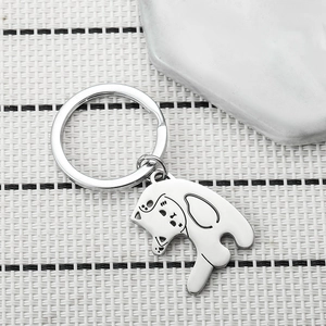 Close-up of silver cat and dog shaped metal charms on a textured natural background