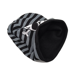 Detail of black and gray striped knit beanie with white skull pattern and tight texture