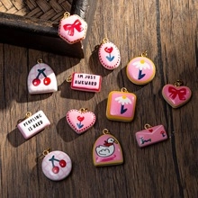 Close-up of assorted enamel floral charms with cute cherry and bow patterns
