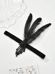 Detail of 1920s black feather headband with velvet ribbon and decorative bead flower