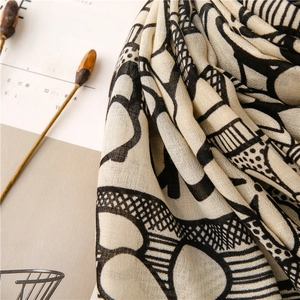 Artistic printed scarf detail featuring black hand-drawn lines and soft geomatric patterns
