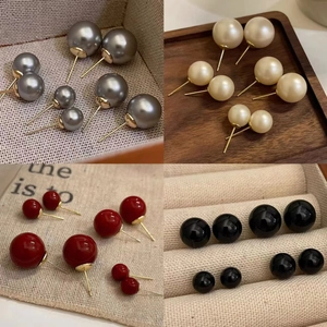 Minimalist double-sided pearl stud earrings in grey, gold, red, and black finishes